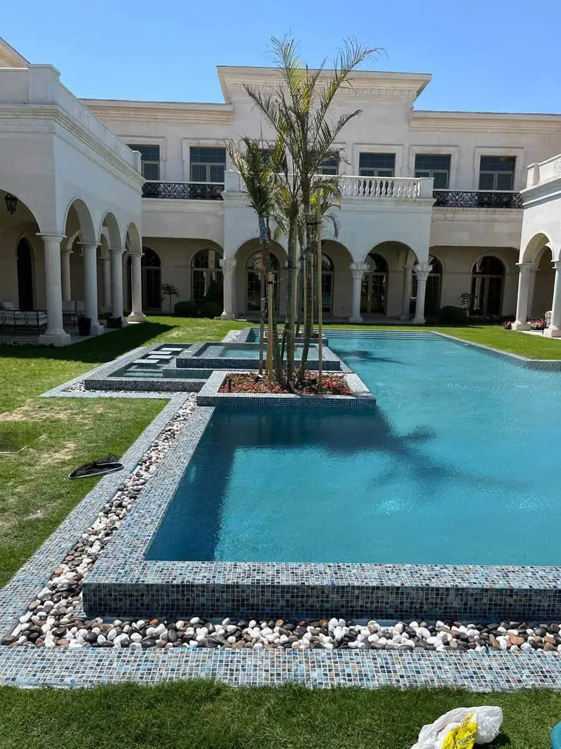 Pool finished in blue glass mosaic with a pebble border